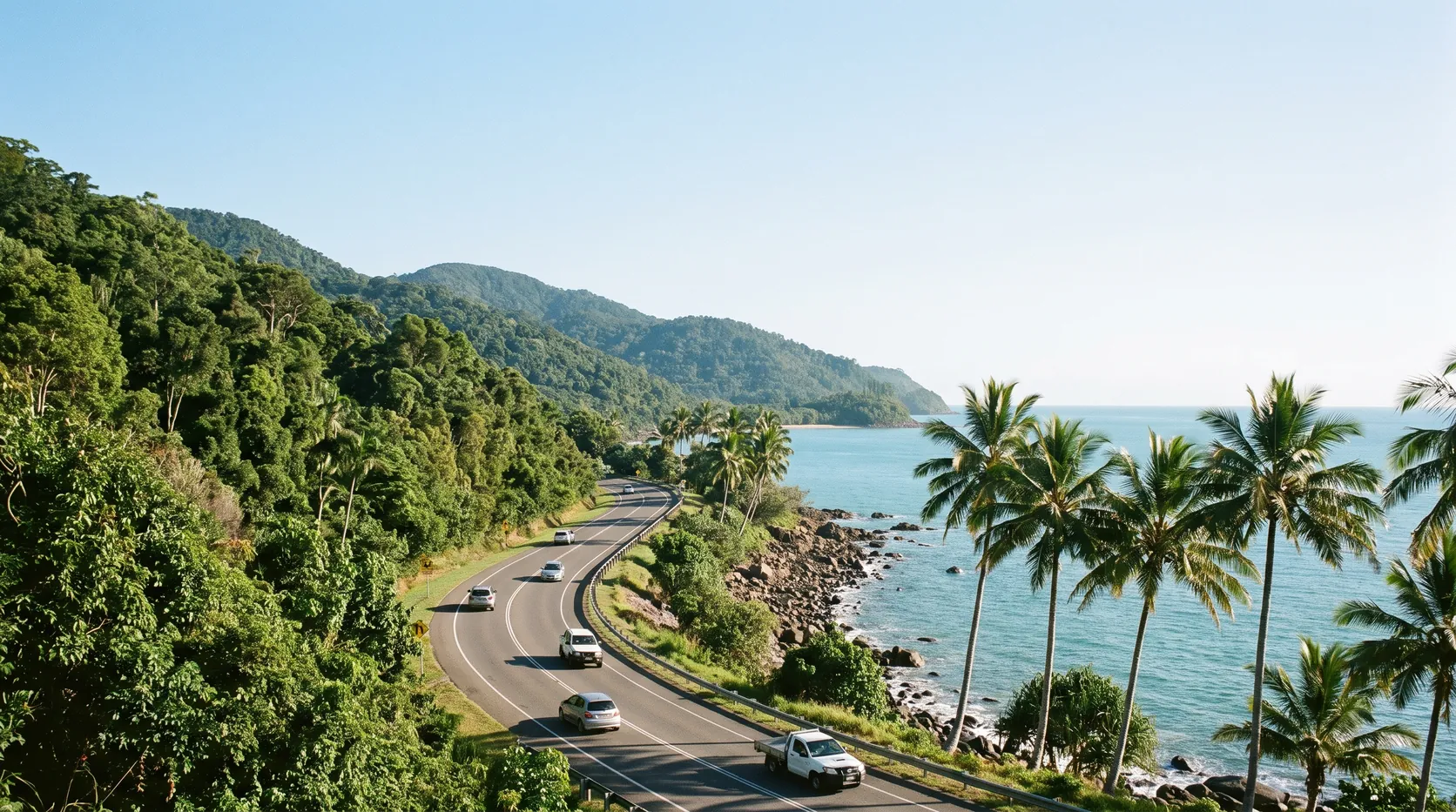 The coast road north of Cairns winding between rainforest and the sea